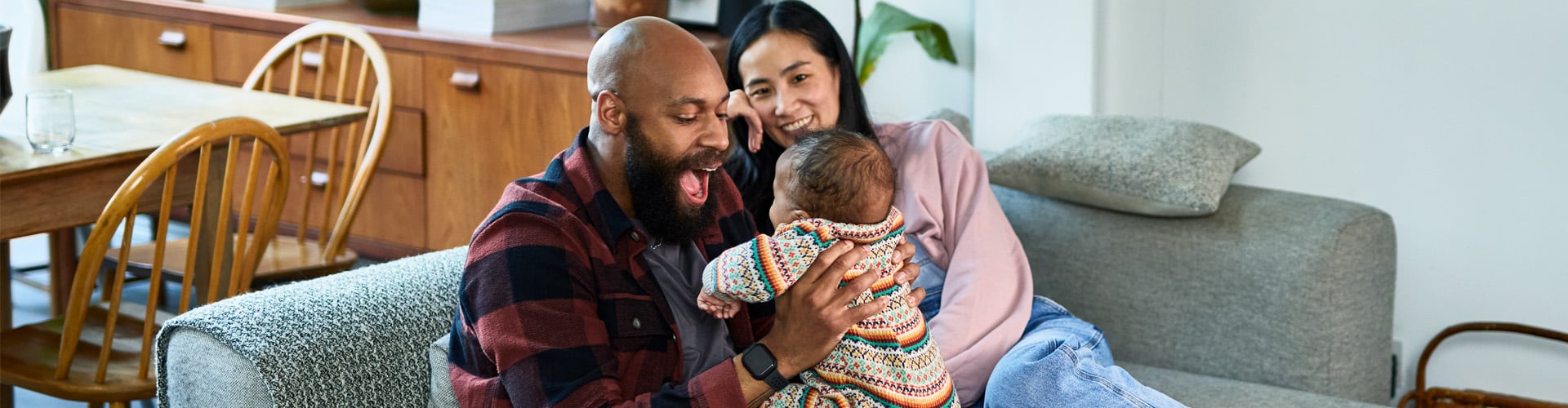 Mixed race couple family sitting in the living room with their baby