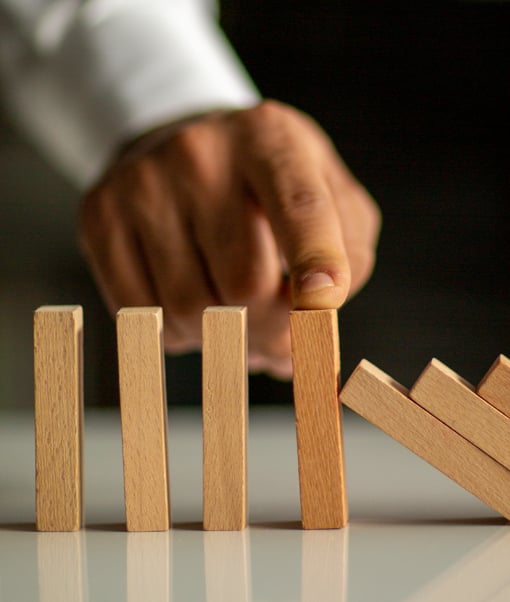 Person balancing a row of wooden dominoes